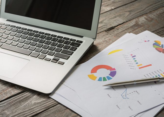 Financial charts on the table with laptop