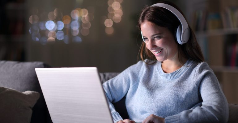 Happy Girl Wearing Headphones Watching And Listening Videos On L